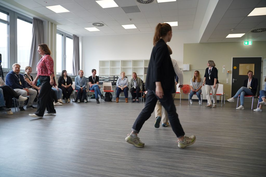 mehrere Personen tauschen Plätze im Rahmen eines aktivierenden Kennenlernspiels